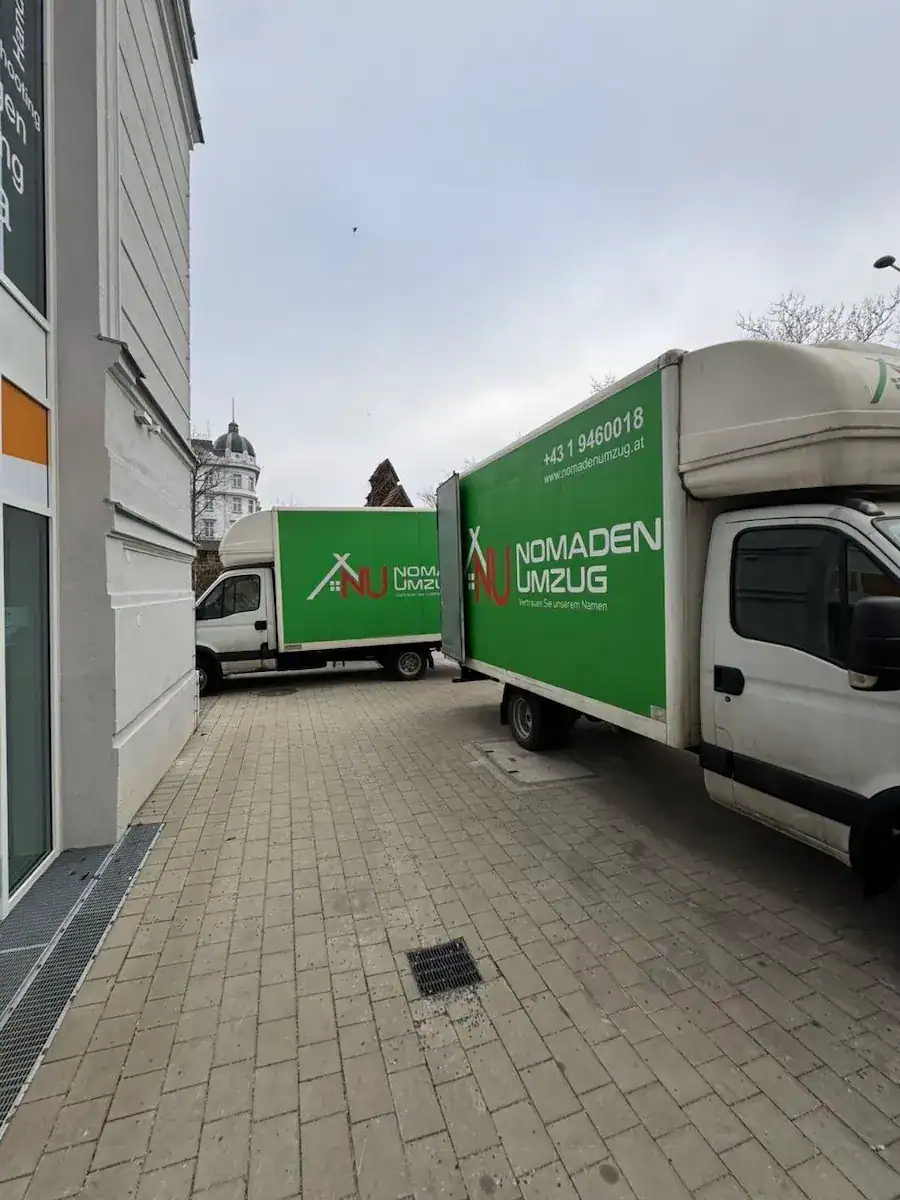 Zwei LKW von Nomaden Umzug parken vor einem Wiener Wohnhaus bei einem Umzugseinsatz