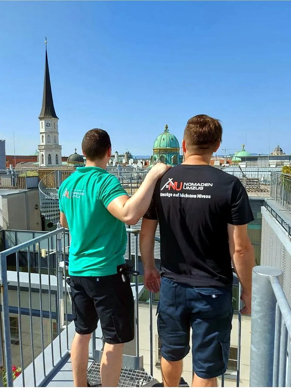 Darko Ivanković und Adnan Duranović von hinten auf einer Dachterrasse über der Wiener Innenstadt